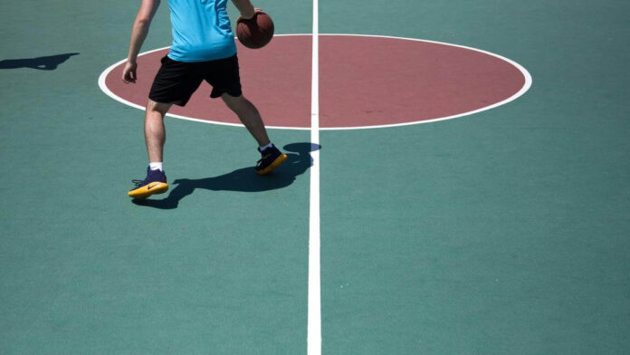 Dribbling basketball on basketball court